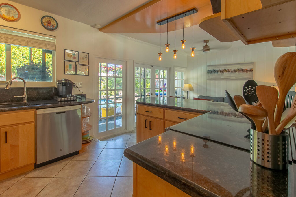 Professional real estate photography of a spacious kitchen with wooden cabinets and granite island in Fort Lauderdale by AdsMiami